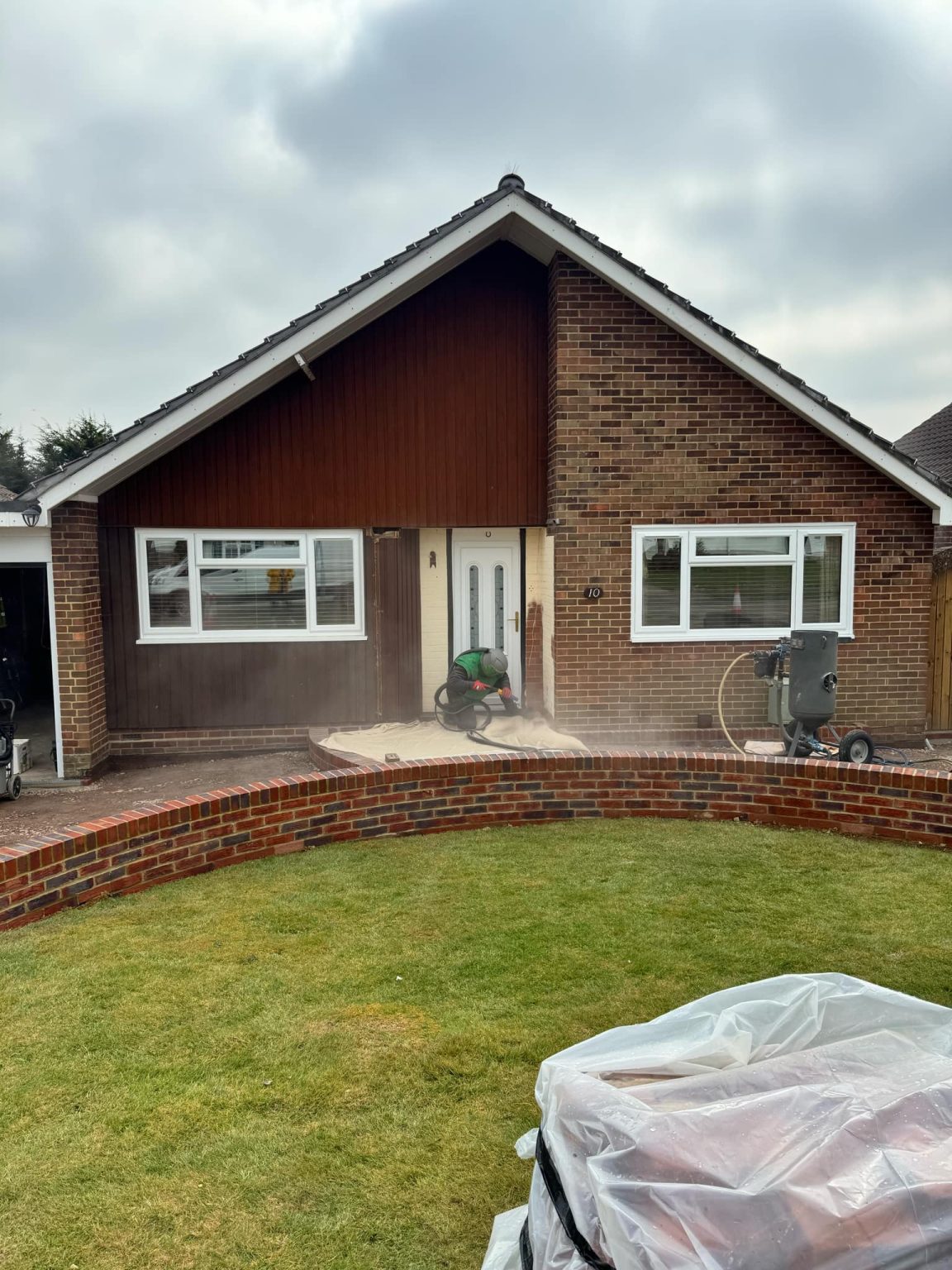 Sandblasting the front of a bungalow on site