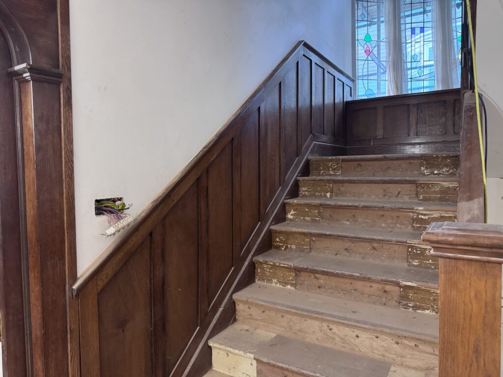 Dark oak stair rail before soda blasting, Brighton